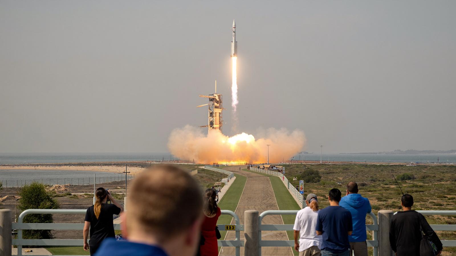 A launch vehicle lifts off on a column of flame and smoke.